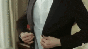 Image of a person buttoning up their suit.